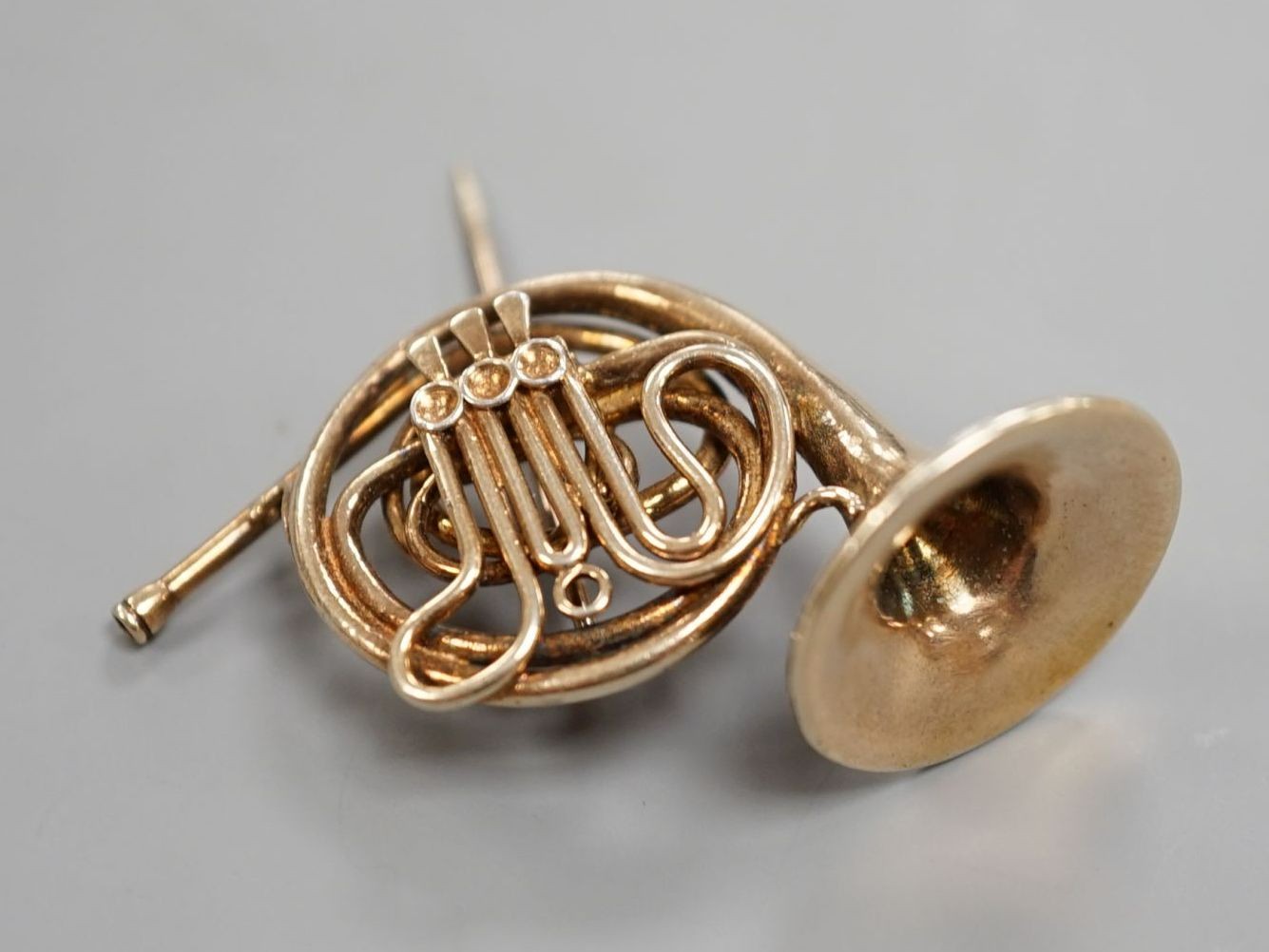 A modern silver gilt brooch, modelled as a French horn, maker, JC, London, 1981, 30mm.